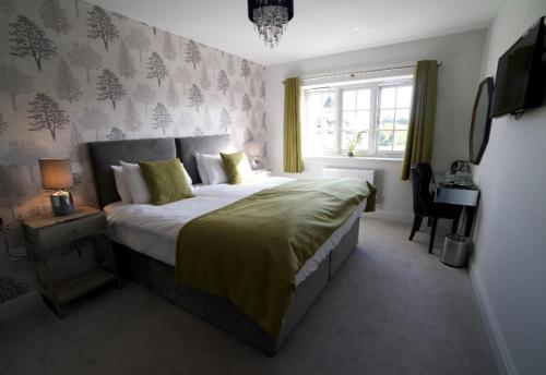 奥尔顿The Binsted Inn的一间卧室设有一张大床和一个窗户。