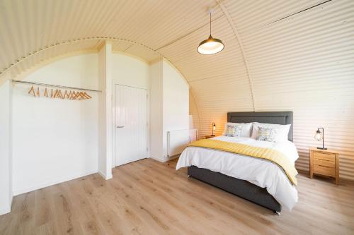 科姆里Cultybraggan Hut 35的一间卧室设有一张床和拱形天花板