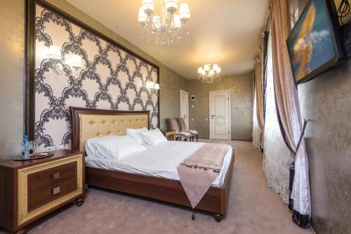 克拉斯诺达尔Гостиница Альвита Краснодар Центр的一间卧室配有一张床和一个吊灯