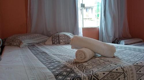 伦索伊斯Pousada Casa da Neuzita的一间卧室配有带毛巾的床