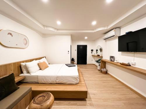 格兰岛KohLan Hansa的一间卧室配有一张床、一台电视和一张沙发