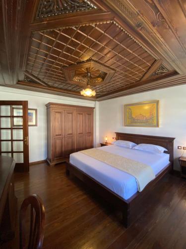 培拉特Boutique Hotel Muzaka (Historic Center)的一间卧室设有一张带木制天花板的大床