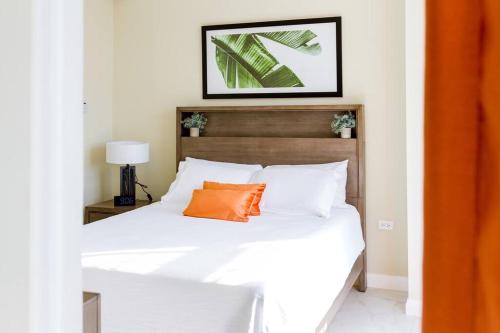 金斯敦Suite Retreat at The Lofts的一间卧室配有一张带橙色枕头的床