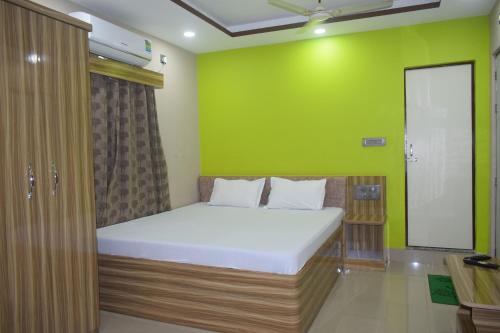 西里古里Airport Lodge的绿色墙壁间的一张床位