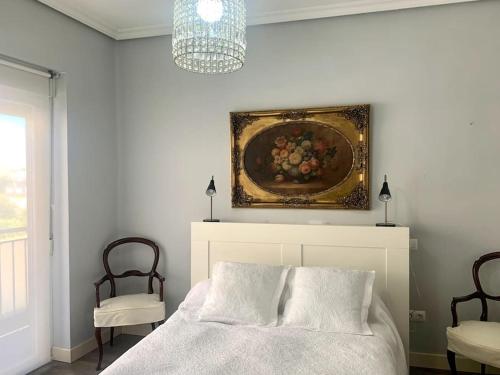 阿维拉Tiger (wifi)的卧室配有一张床,墙上挂有绘画作品