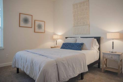 圣安东尼奥The Oasis at Hays-All new 3 bdrm, 2 bath retreat的一间卧室配有一张带两张桌子和两盏灯的床。