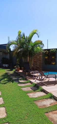 伊瓜苏Pousada Casa Bom Sono的院子内种有长椅和棕榈树的走道