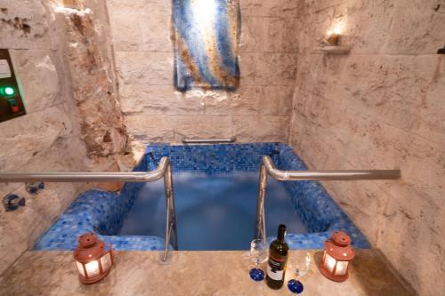 阿瑞达伊亚Ξενώνας Μαίανδρος的浴室设有蓝色浴缸,在柜台上装有瓶子