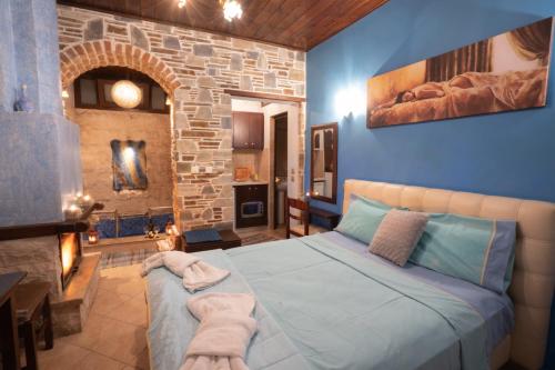 阿瑞达伊亚Ξενώνας Μαίανδρος的一间卧室设有一张床和石墙