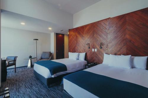 拉巴斯阿提克斯酒店的酒店客房,配有两张床和椅子