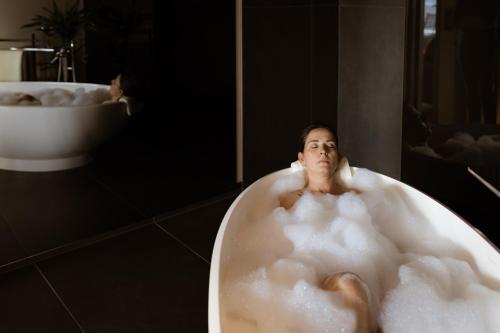 蒂鲁罗Culinaria living的坐在浴室浴缸里的女人