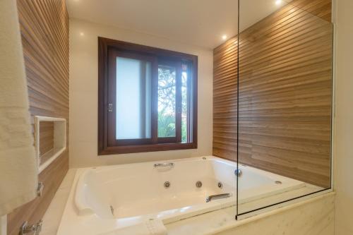 布希奥斯考赖斯康查斯酒店的带浴缸的浴室和窗户