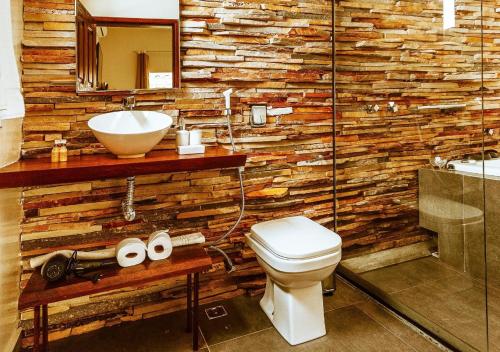 戈亚斯州上帕莱索Pousada Casa de Shiva的浴室设有木墙、水槽和卫生间