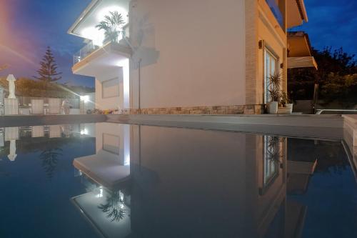 埃斯托利尔Gold Coast Photography Inn的一座晚上设有游泳池的房子