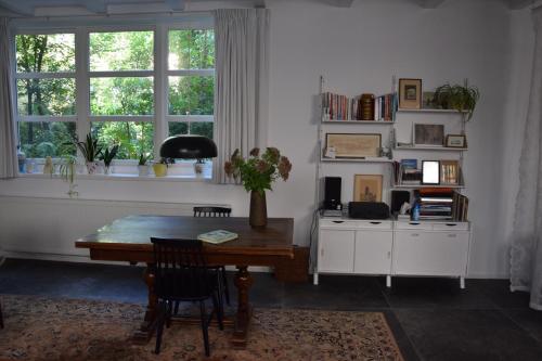 多德雷赫特Villa Conti的客厅配有木桌和窗户。