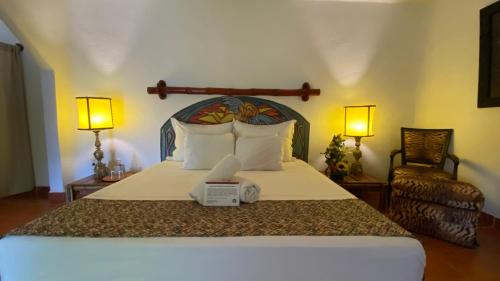Barra Vieja班布达中心霍利斯提科旅馆的一间卧室配有一张大床、两盏灯和一张四柱床