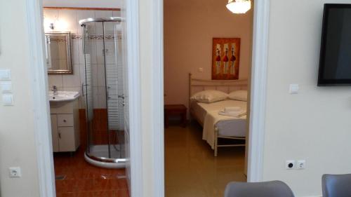 阿约斯尼奇塔斯Pantazis Studios in Agios Nikitas的一间卧室配有一张床,浴室设有水槽