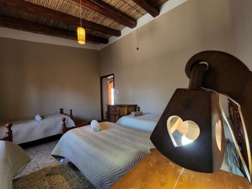 卡奇HOSPEDAJE LA CASONA DE CACHI的一间卧室设有两张床和心形镜子