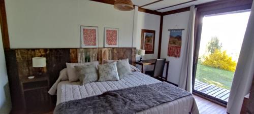 富塔莱乌富Refugio Los Cipreses Hotel的一间卧室设有一张床和一个大窗户