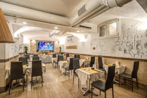 罗马Hotel Centro Cavour Roma的餐厅设有桌椅和投影屏幕