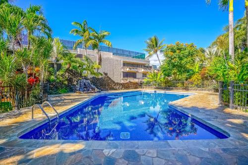 科洛阿Prince Kuhio 323的一座拥有蓝色海水和棕榈树的游泳池