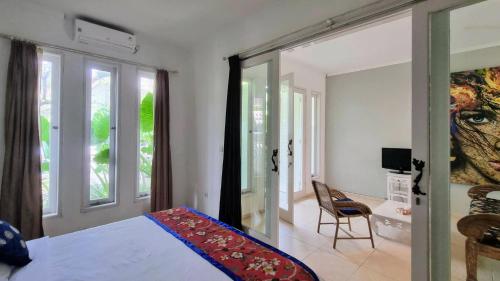 沙努尔Starling villas的一间卧室设有一张床、一个窗口和一把椅子