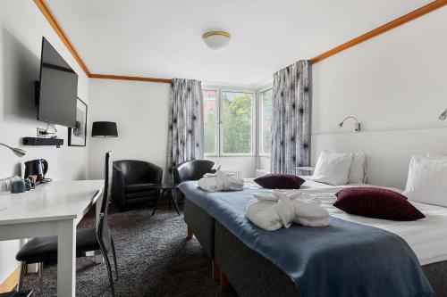 斯德哥尔摩康姆贝斯特韦斯特酒店的酒店客房配有两张床和一张书桌
