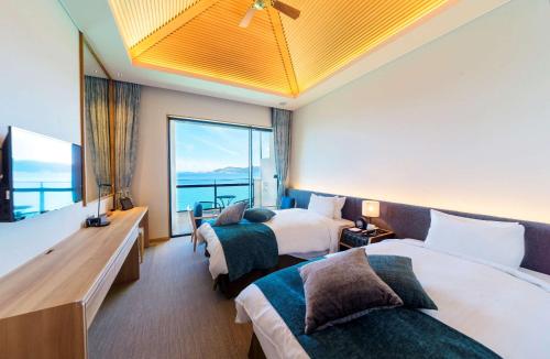 名户贝斯特韦斯特冲绳蔻琦酒店的酒店客房设有两张床和大窗户。