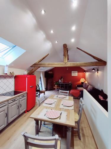 弗农La Mansarde的厨房以及带桌子和红色冰箱的用餐室。