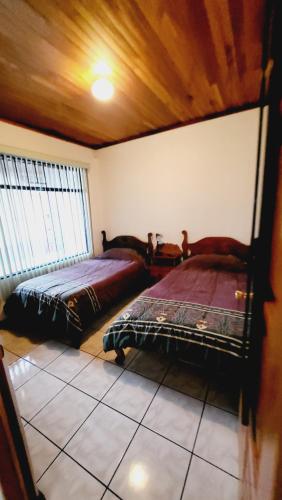 阿拉胡埃拉Don Carlos Place的一间卧室,配有两张床