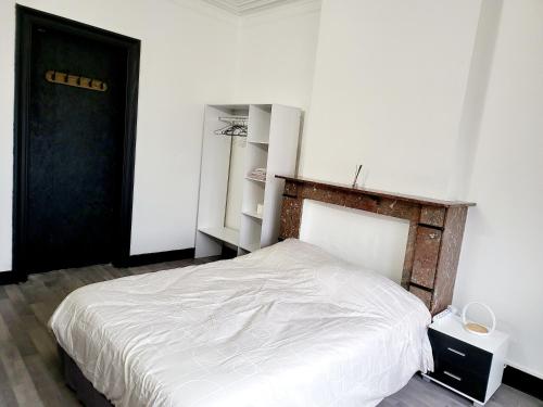 沙勒罗瓦Private industrial room in center of Charleroi的卧室配有白色的床和黑色的门