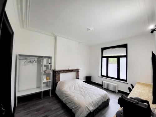 沙勒罗瓦Private industrial room in center of Charleroi的白色的卧室设有床和窗户