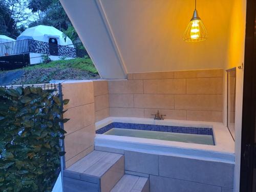 别霍港HOTEL, VILLAS y GLAMPINGS MYA -PUERTO VIEJO, Limon, CR的窗户客房内的浴缸