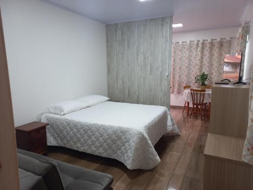 特雷齐蒂利亚斯Hospedaria Mitterer的卧室配有白色的床和桌子