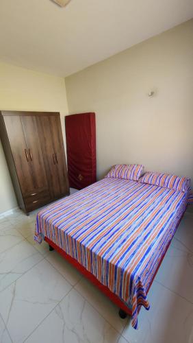 维索萨-杜塞阿拉Casa do Jerff的卧室内的一张大床,配有木制橱柜