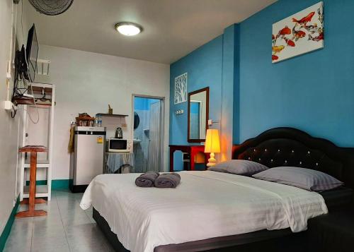 卡伦海滩Sala Bua Room的卧室配有白色大床和蓝色的墙壁