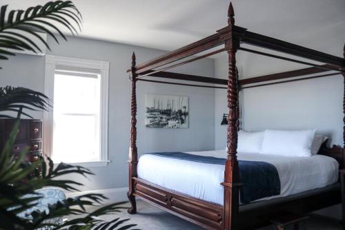 罗克波特Emerson Inn By The Sea的一间卧室设有天蓬床和窗户。