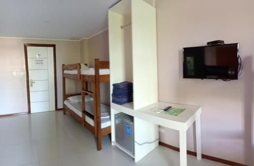 波尔多·格尼拉Answer hotel的小房间设有书桌和墙上的电视