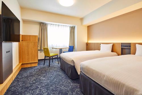 东京开赛卢米埃尔酒店的酒店客房设有两张床和电视。