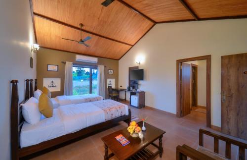 DhanwārAranyak Resort Kanha的一间卧室配有一张大床和一张桌子
