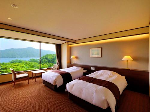 宫古市海滨净土公园酒店的酒店客房设有两张床和大窗户。