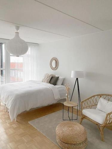 埃斯波Modern and cozy apartment with Sauna的白色卧室配有一张大床和椅子