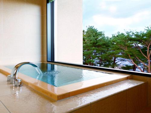 宫古市海滨净土公园酒店的浴缸设有窗户和水槽