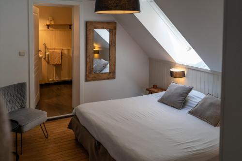 迪尔森-斯托科姆玛尔塔克酒店的卧室配有白色的床和镜子