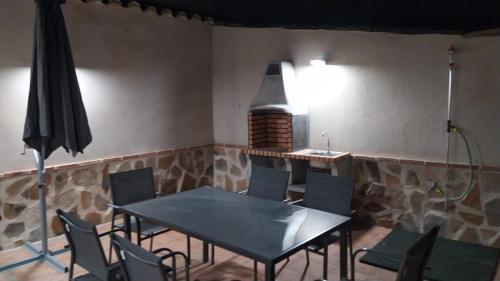 GuadamurCasa FIGUEROA en Guadamur, próximo a Puy du Fou的用餐室配有桌椅和遮阳伞