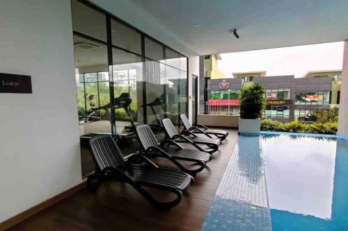 普崇16 Sierra Puchong Zentro 5 人 Supreme二房公寓的游泳池旁的一排椅子