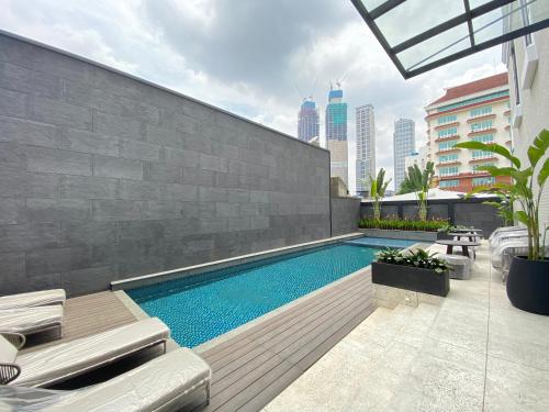 雅加达Maia Hotel Jakarta的建筑物一侧的游泳池