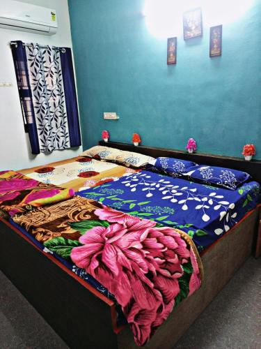 甘吉布勒姆Sai Homestay的一间卧室配有一张色彩缤纷的床单