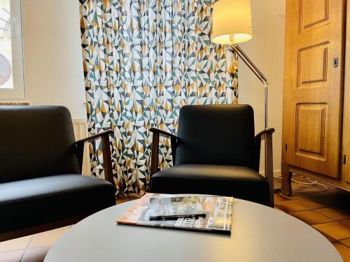 法尔肯堡法尔肯堡度假屋的一间设有两把椅子和一张桌子的等候室