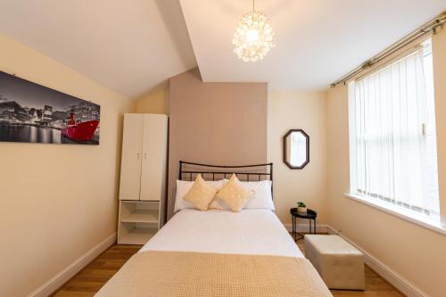 利物浦Holly Room的一间卧室配有一张床和一个吊灯